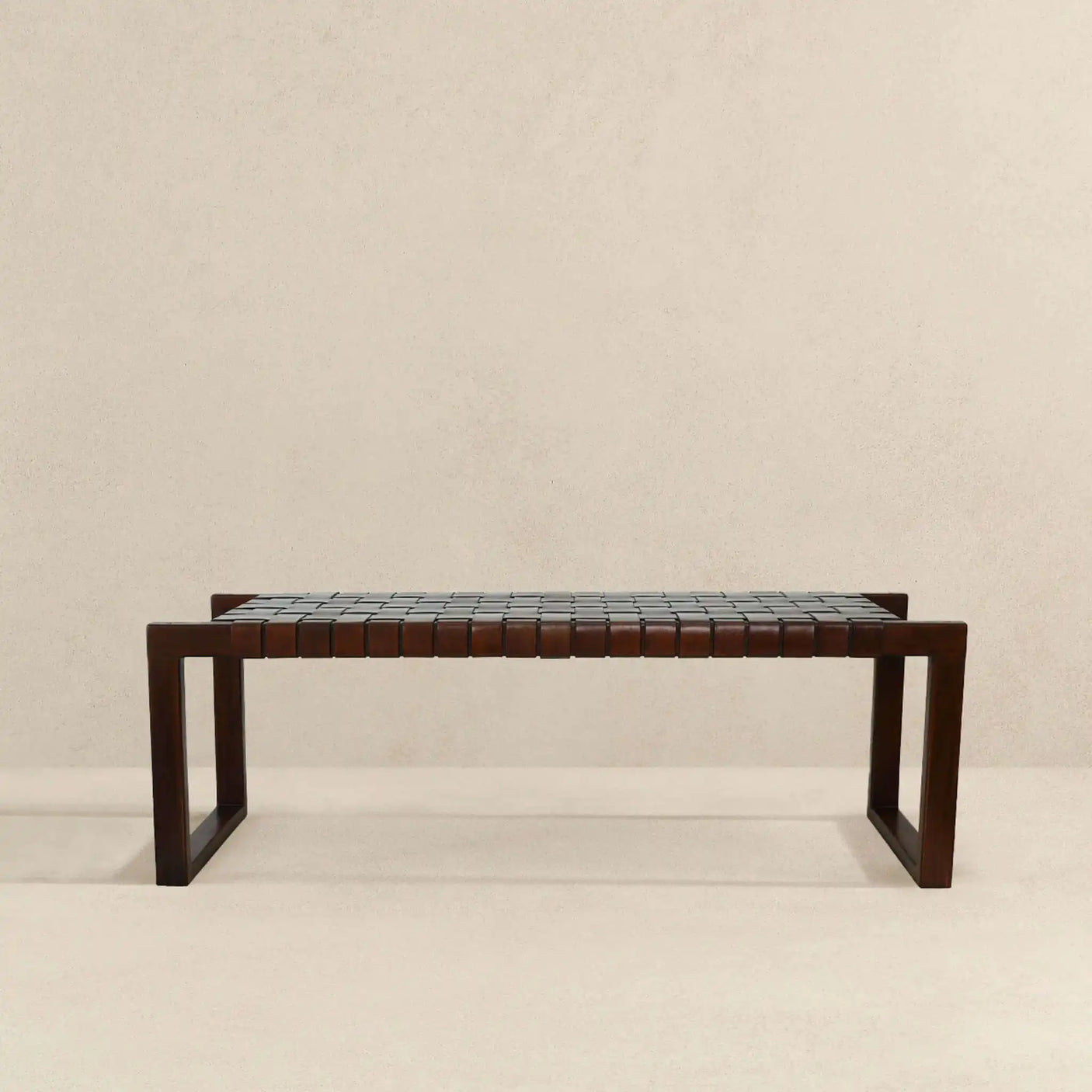 Modern wooden bench with woven leather seat on beige background