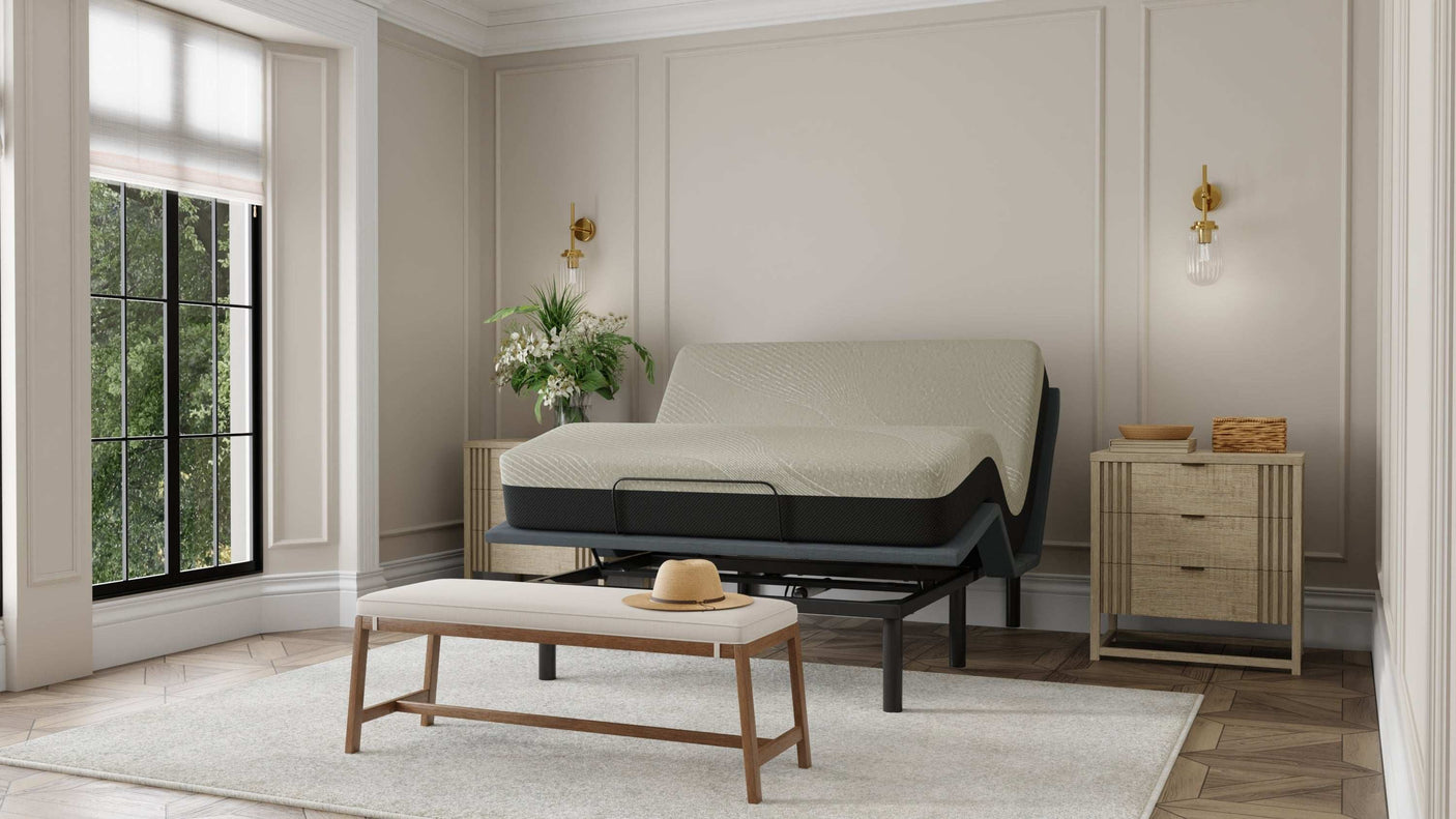 Modern bedroom with adjustable bed frame, upholstered bench, and natural wood nightstands