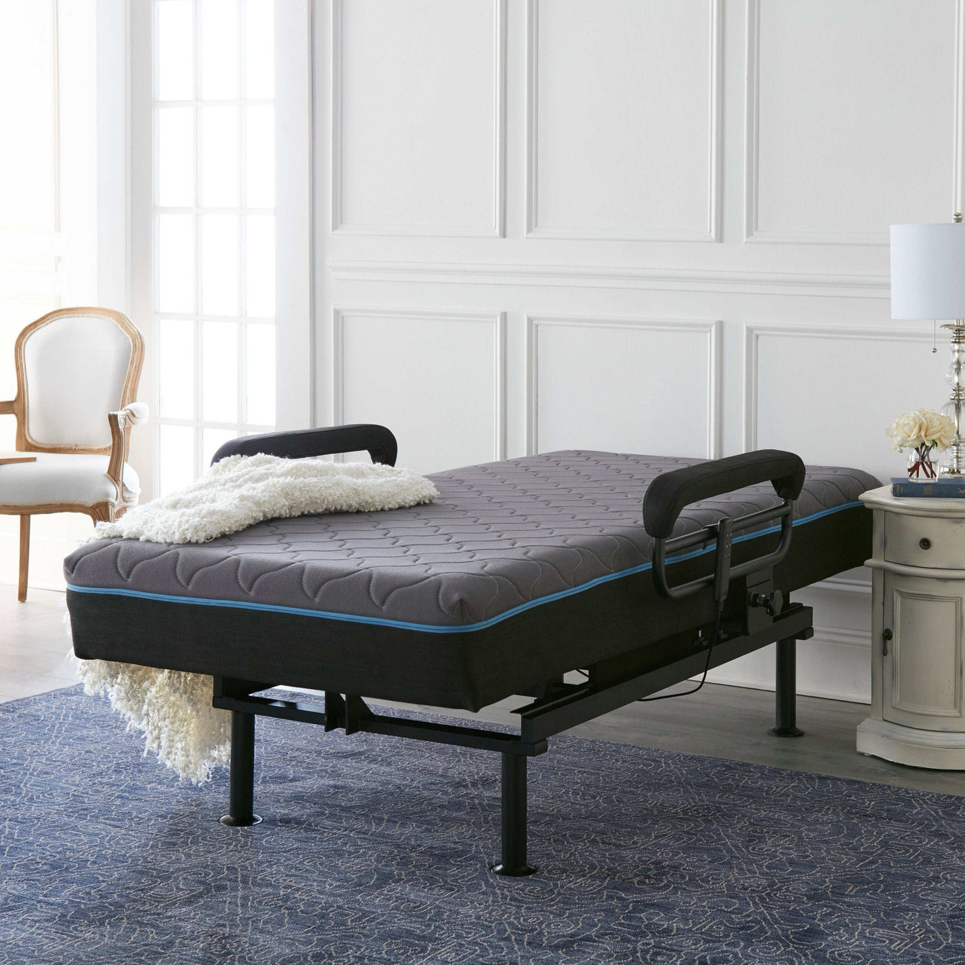 Adjustable bed with mattress and side rails in a bright bedroom
