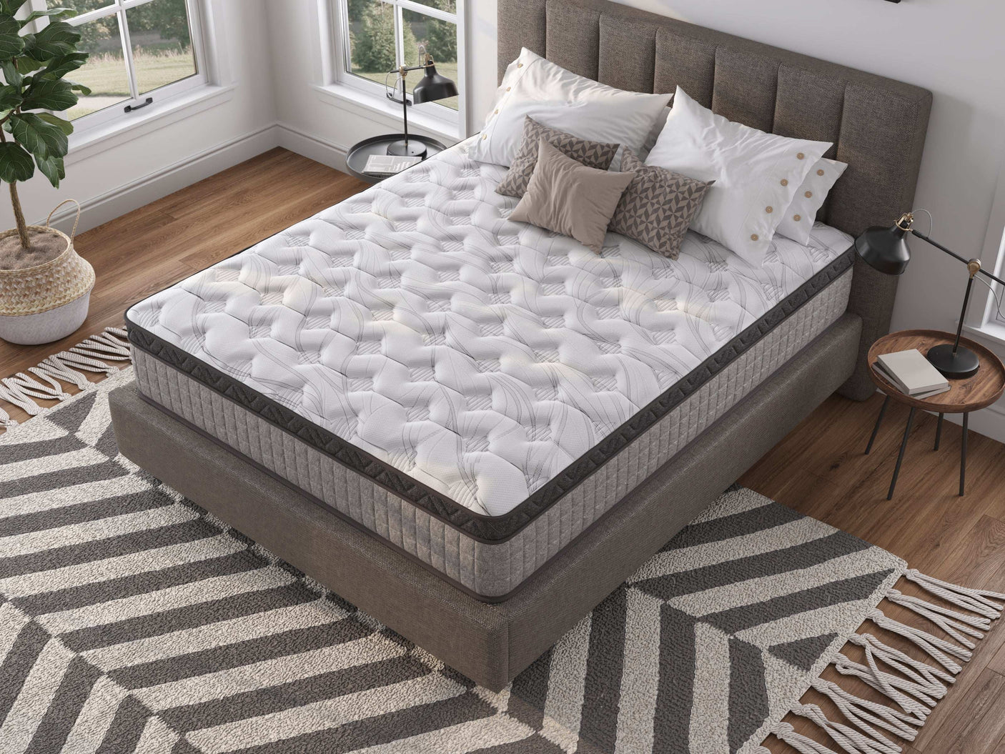 Modern bedroom with a quilted mattress on a grey upholstered bed, geometric rug, and pillows