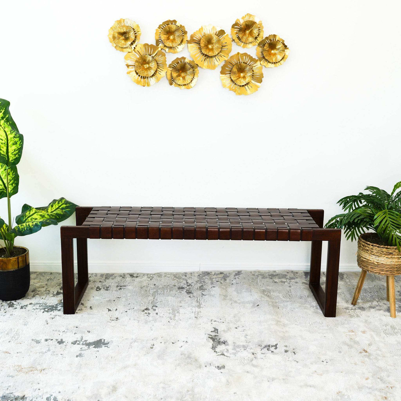 Modern entryway with dark wood bench, gold wall art, and potted indoor plants