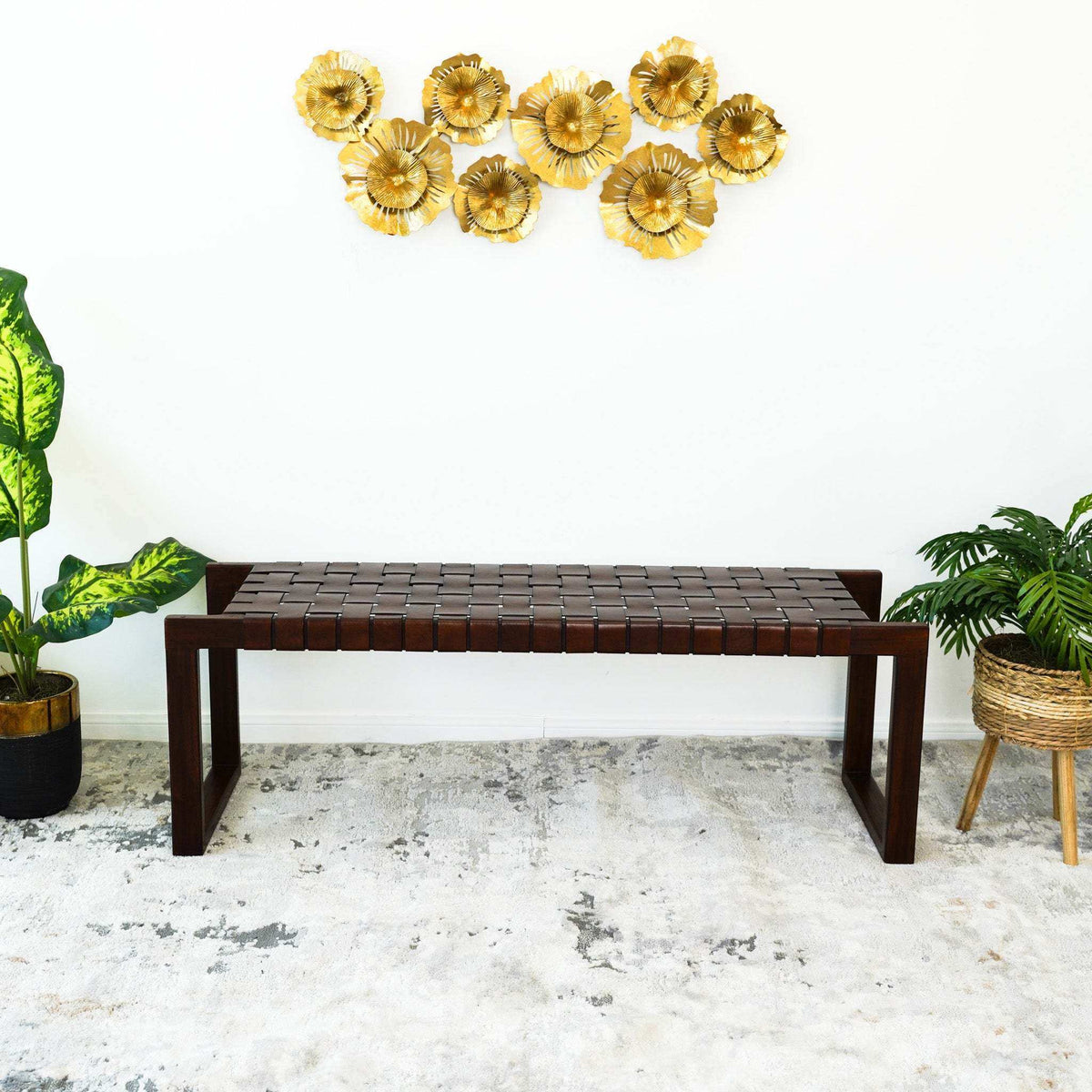 Modern entryway with dark wood bench, gold wall art, and potted indoor plants