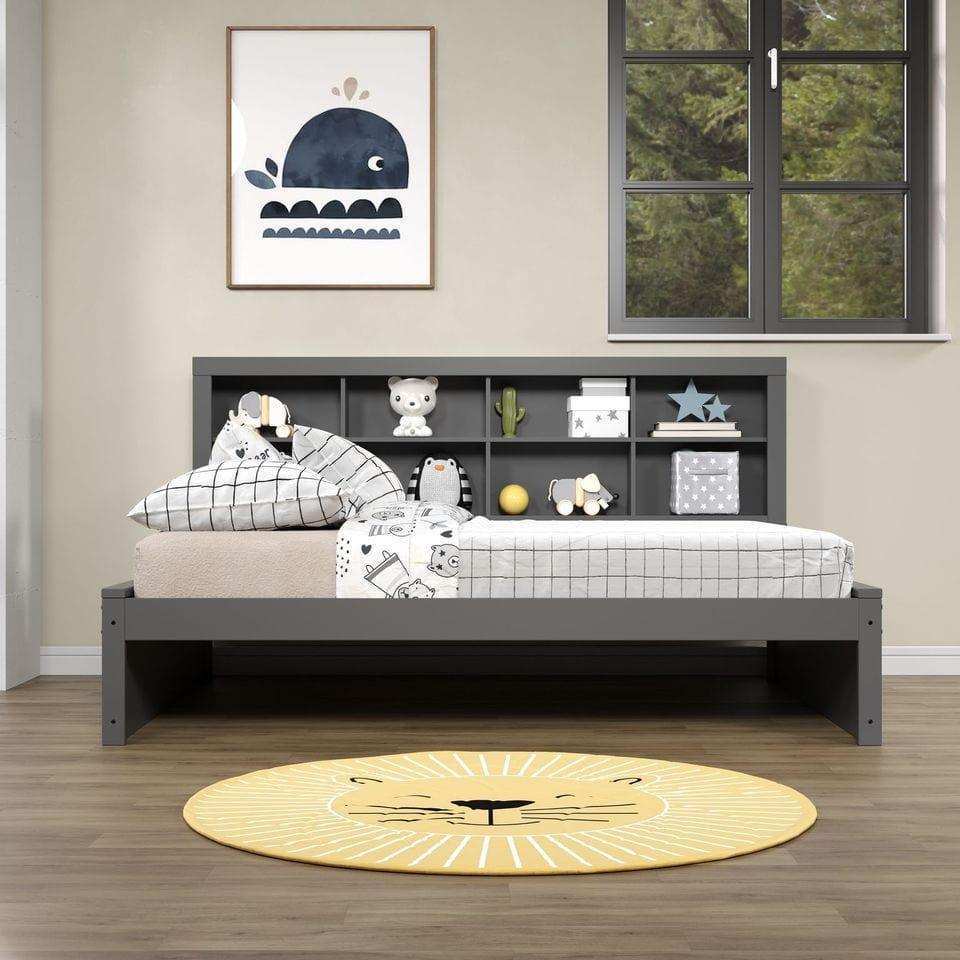 Dark gray full daybed with bookcase headboard in bright kids room, playful bedding, wall art, and yellow lion rug
