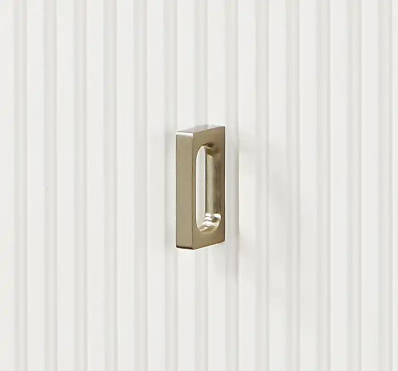 Brushed nickel rectangular cabinet pull on white vertical paneled door