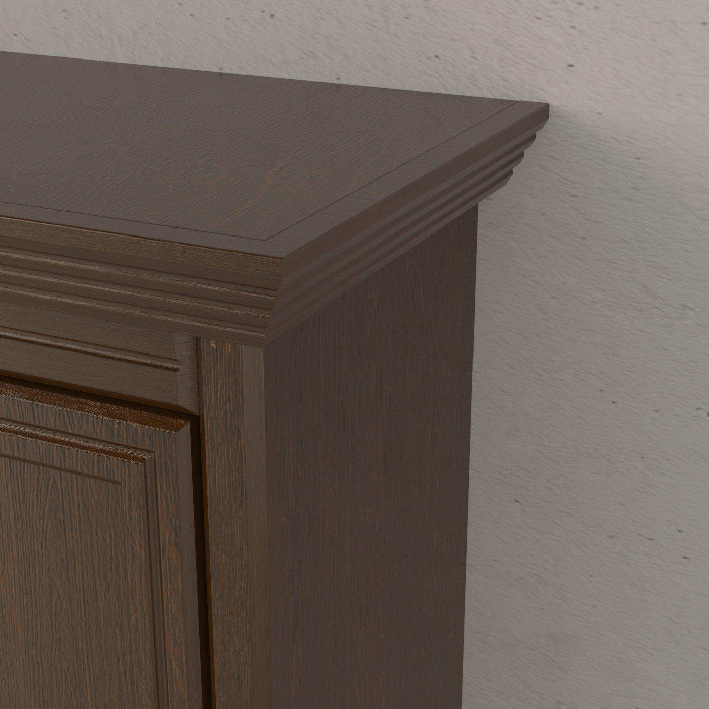 Close-up of walnut wood Murphy bed headboard with detailed trim against a light wall