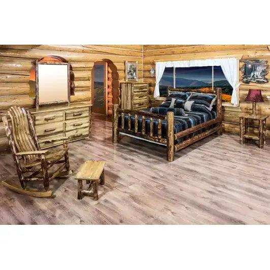 Rustic log cabin bedroom with wooden Eastern king bed, dresser, and mountain view window