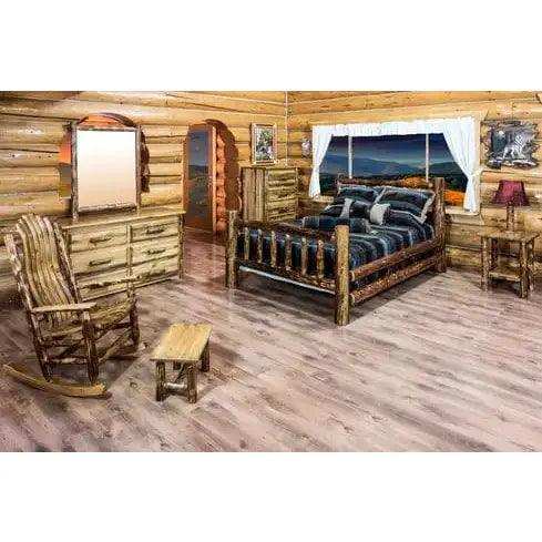 Rustic log queen bed in a wood cabin bedroom with dresser, rocking chair, and mountain view.