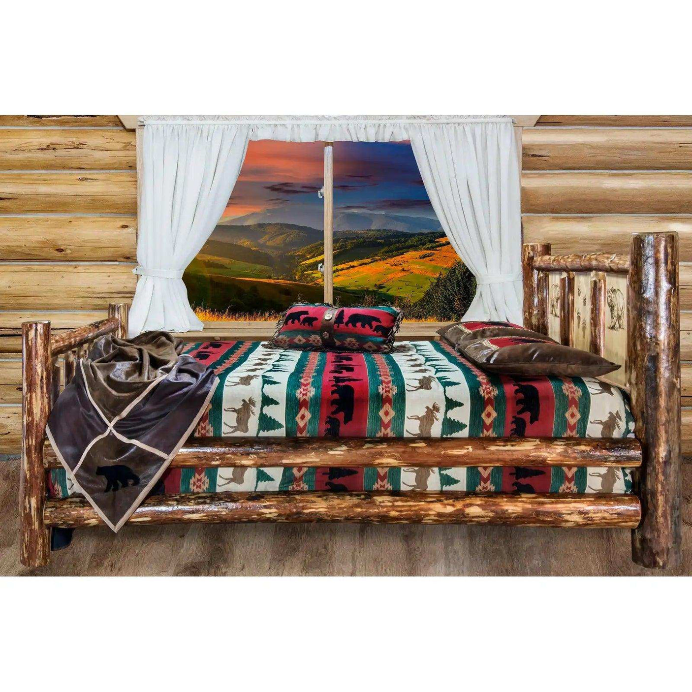Rustic log queen bed with wildlife-themed bedding in a cabin room, mountain view window