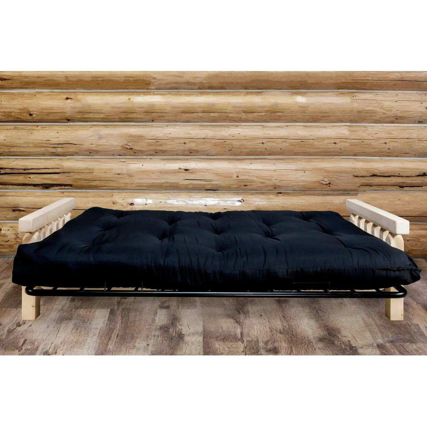 Homestead futon frame with black mattress, clear lacquer finish, rustic wood backdrop