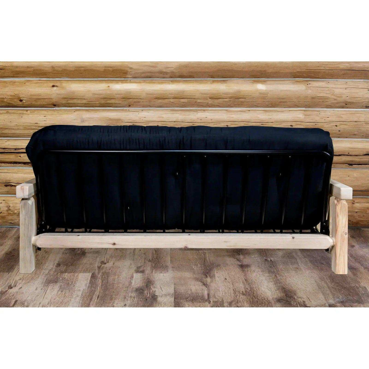 Homestead futon frame with black mattress and clear lacquer finish in log cabin room