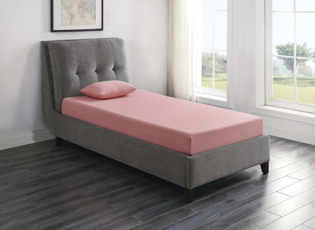 Pink mattress and pillow on modern gray upholstered bed in a bright bedroom with large windows