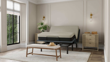 Modern bedroom with adjustable bed frame, upholstered bench, and natural wood nightstands