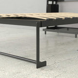 Modern metal platform bed frame with wood slats on a concrete floor