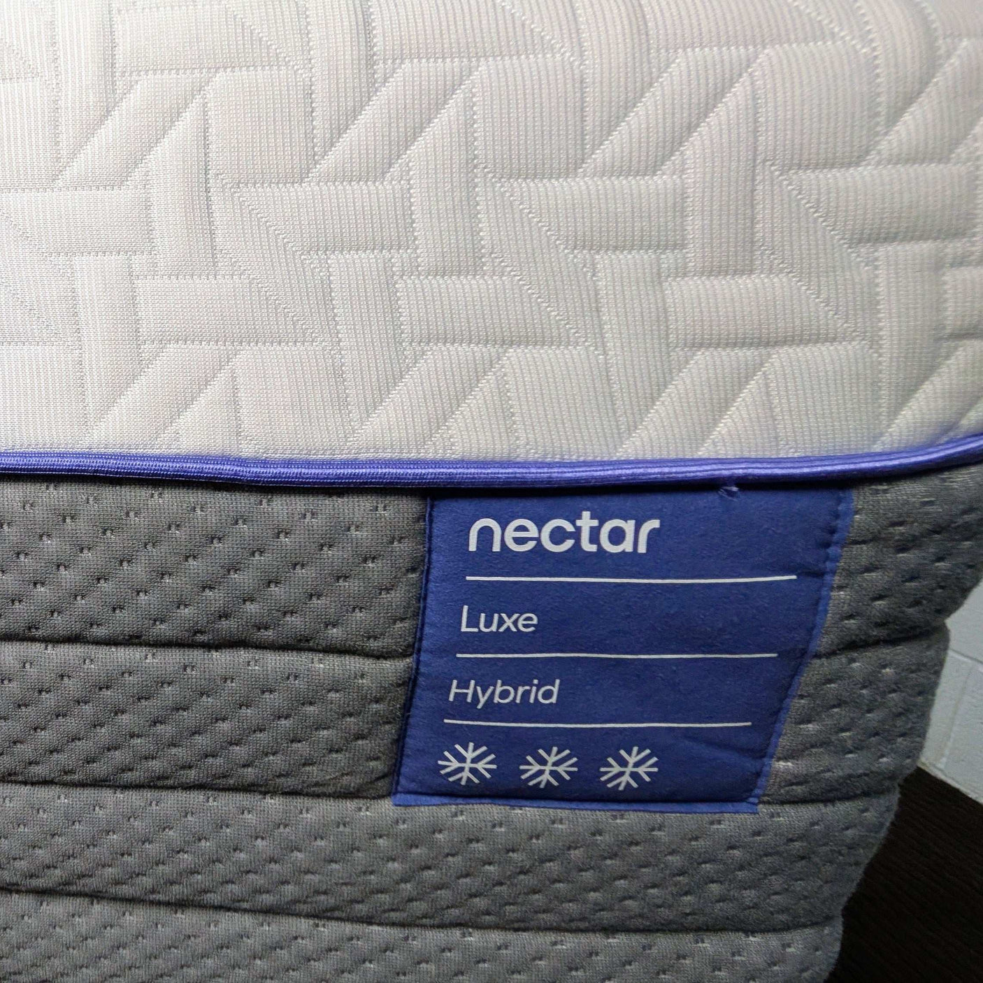 Nectar Luxe Hybrid mattress with a close-up of the brand label.