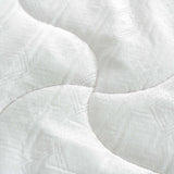 Close-up of white quilted mattress fabric with wave stitching pattern