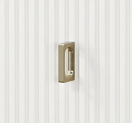Brushed nickel rectangular cabinet pull on white vertical paneled door