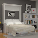 White Murphy bed with desk in modern bedroom, bookshelf and wall art, wood floor
