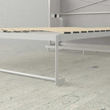 White Murphy bed frame with wood slats and desk in modern minimalist room